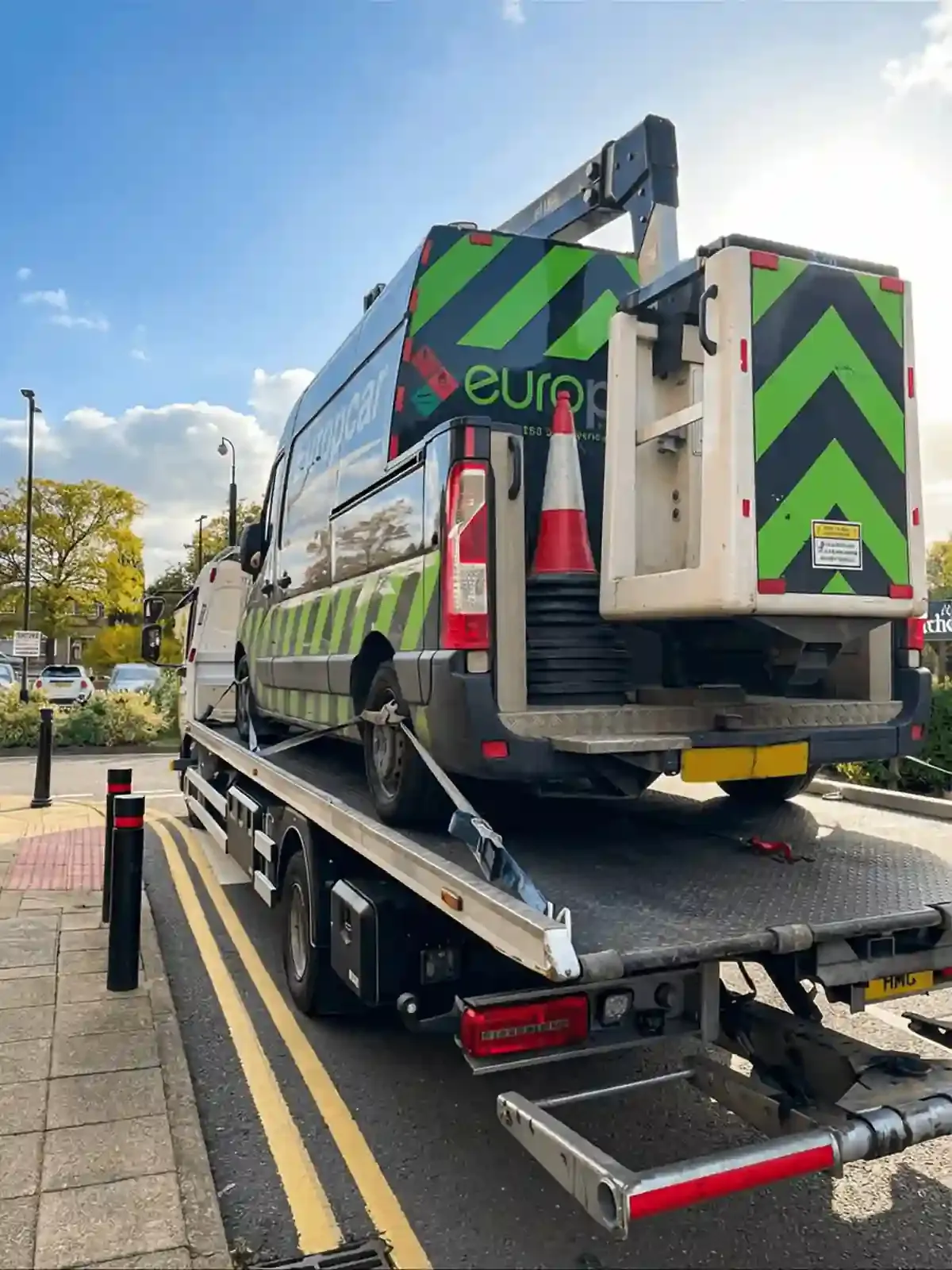 Europcar van being transported on flatbed recovery truck in Stoke-on-Trent