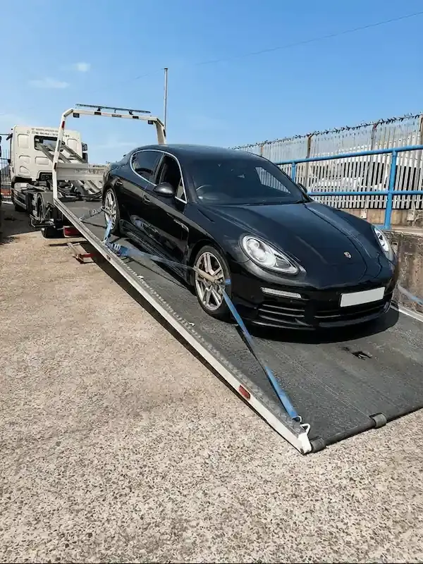 Black Porsche Panamera luxury car transport on flatbed